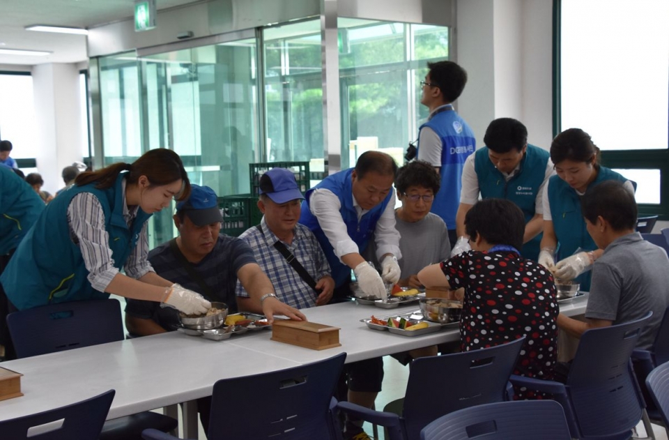 27일 ‘건강한 여름나기 福삼계탕 나눔행사’에 참여한 원자력환경공단과 대구은행 자원봉사단원들이 어른신들의 식사를 돕고 있다.