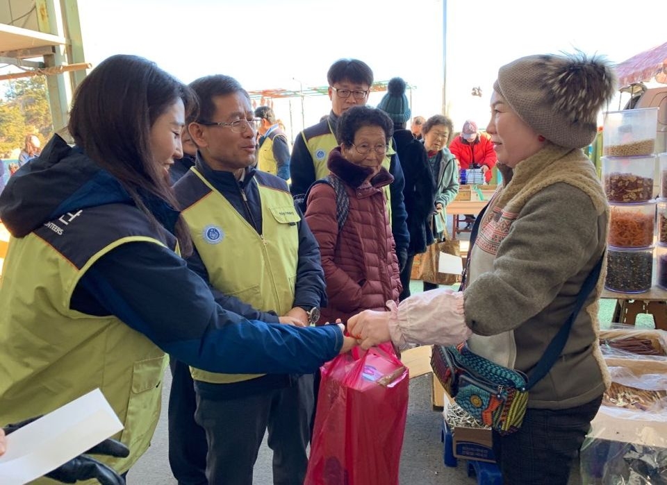 지난 21일 설을 앞두고 ‘전통시장 장보기 행사’에 참여한 한울원전 직원들이 설 물품을 구입하고 상인들과 덕담을 나누고 있다.