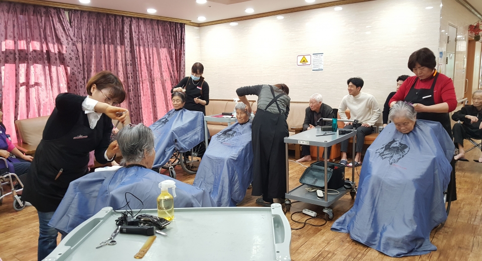 지난 28일 한울원전 헤어스케치 봉사단원들이 어르신들의 머리를 이발해드리고 있다.