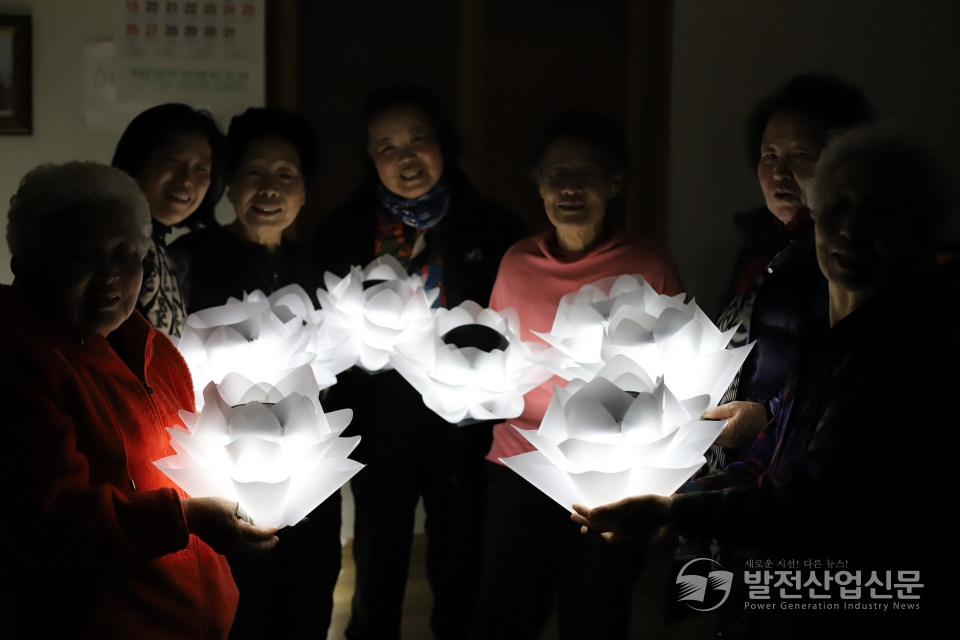 마을 주민들이 폐그물 업사이클링 전등을 설치하기 전 마을회관에서 기념촬영 하고 있다