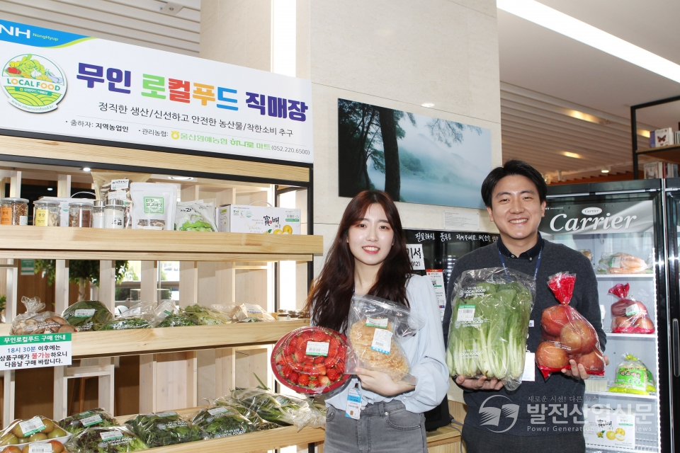 한국동서발전(주) 1층 로비의 무인 로컬푸드 직매장에서 직원들이 농산물을 들어 보이고 있다.
