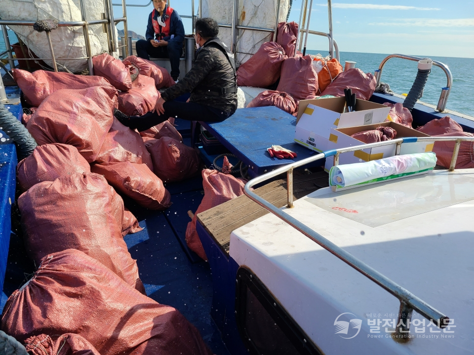한국중부발전(주) 관계자들이 15일 '나무섬'에서 해양폐기물을 수거하고 있다. 수거된 폐기물을 이송 처리하기 위해 선박에 선적하고 있다 .