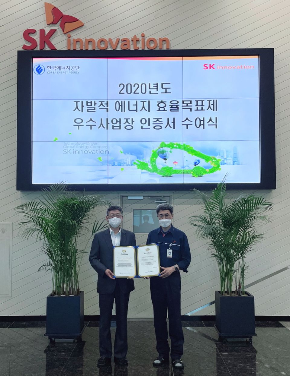 8월 12일 박병춘 한국에너지공단 수요관리이사(왼쪽)가 김진영 SK이노베이션 배터리생산기술본부장(우측)에게 2020년도 자발적 에너지효율목표제 우수사업장 인증서 및 현판을 전달하고 있다.