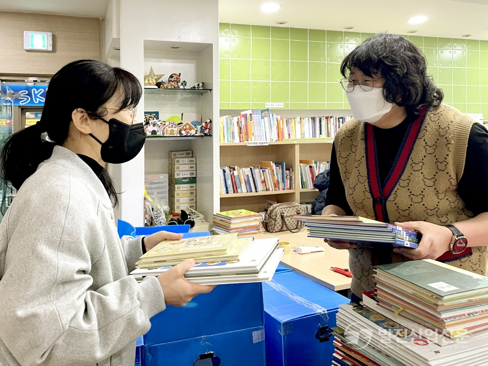 한국동서발전(주) 직원이 예술융합 좋은땅 도서관에 임직원 기부 도서를 전달하고 있다.